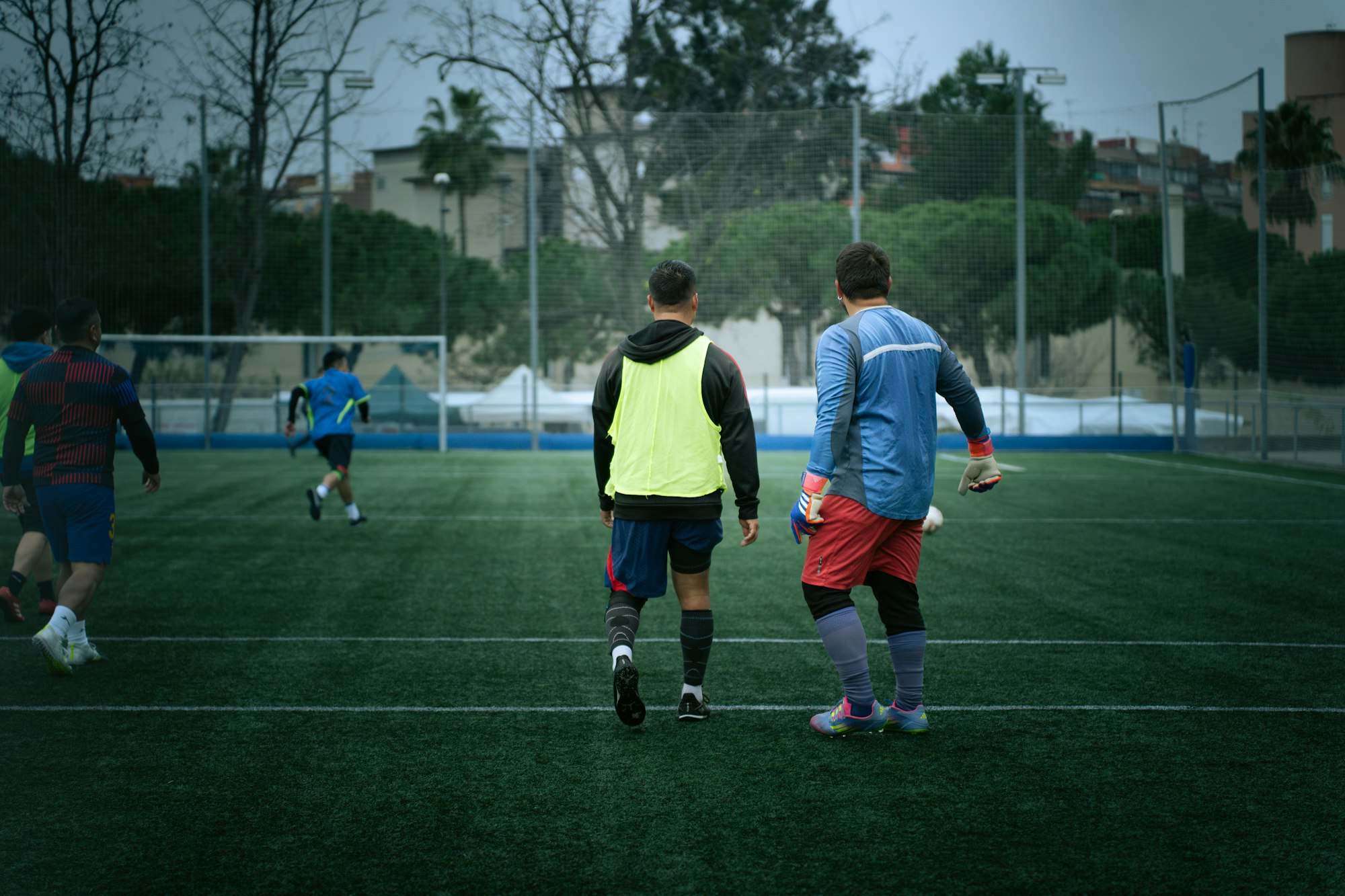 Amateurfußballer mit Leibchen bei einer Trainingseinheit auf dem Kunstrasen